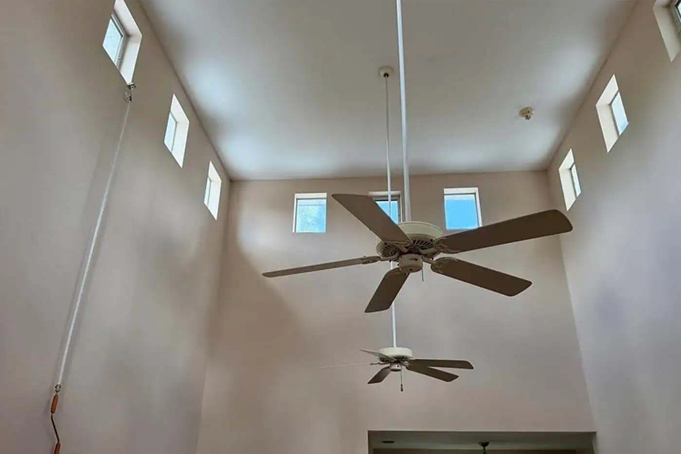 High vaulted ceilings with clerestory windows and ceiling fans in open living space at 5281 Teak Wood Drive, Logan Woods, Naples FL