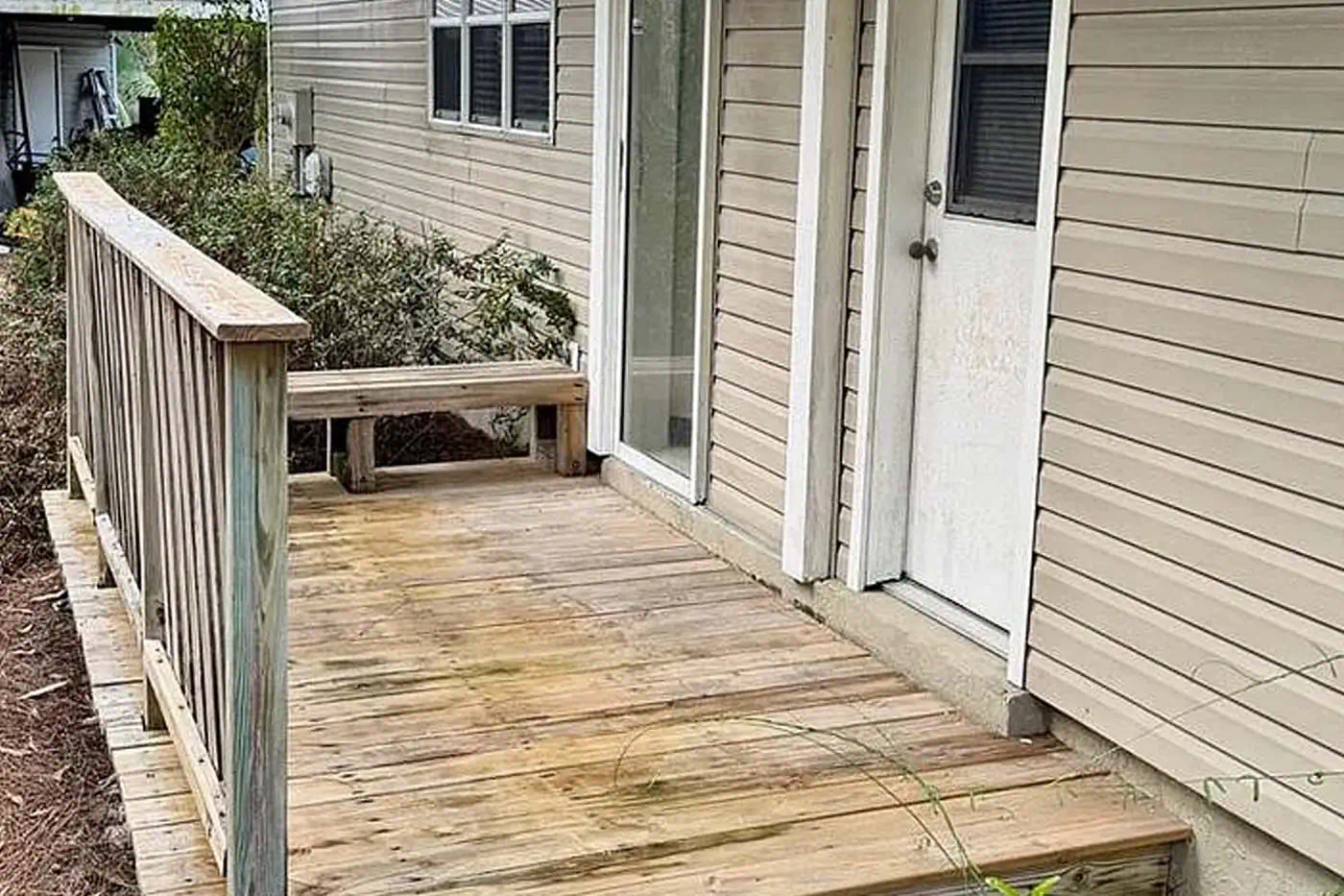 Wooden side deck walkway with railing and exterior access door at 5281 Teak Wood Drive, Logan Woods, Naples FL