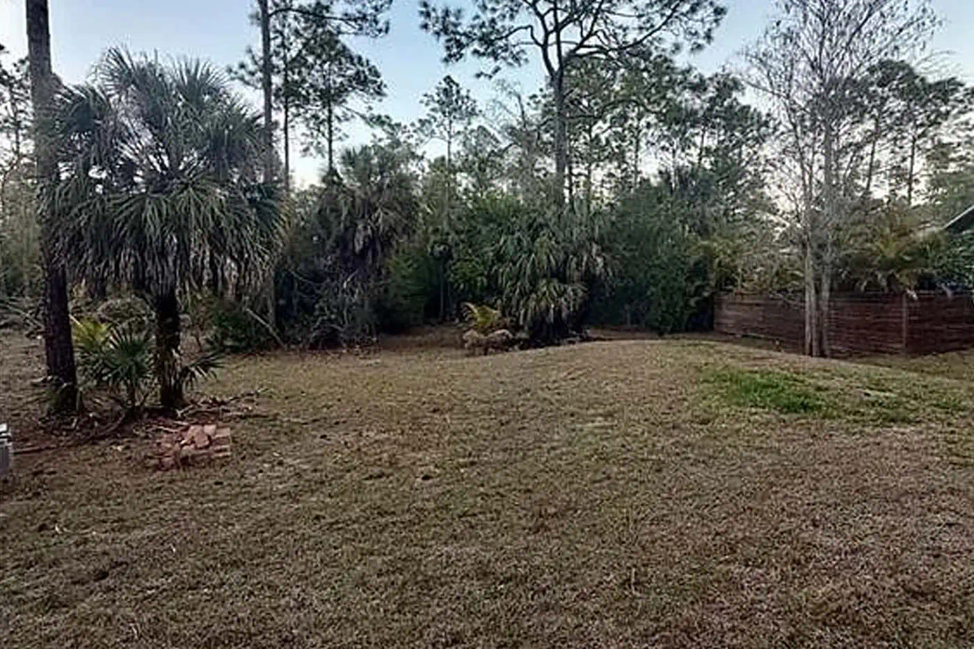 Spacious backyard with mature trees and open lot at 5281 Teak Wood Drive, Logan Woods, Naples FL